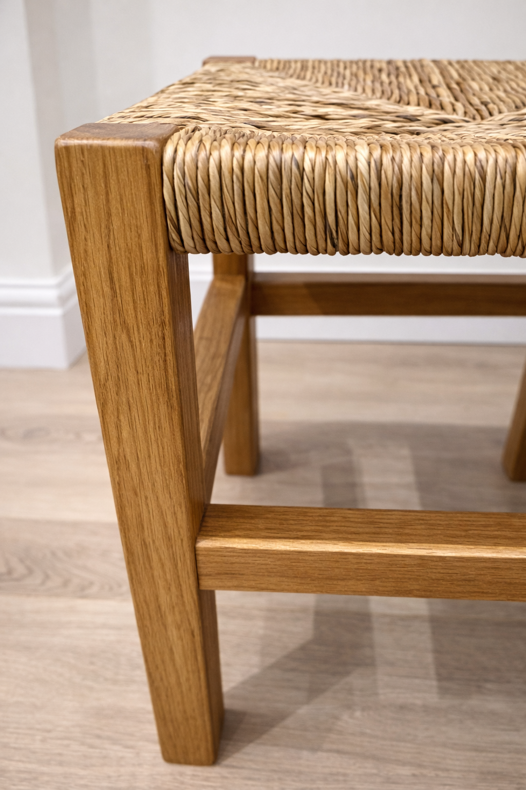 Handmade oak stool close-up detail with rush seat, stained in danish oil